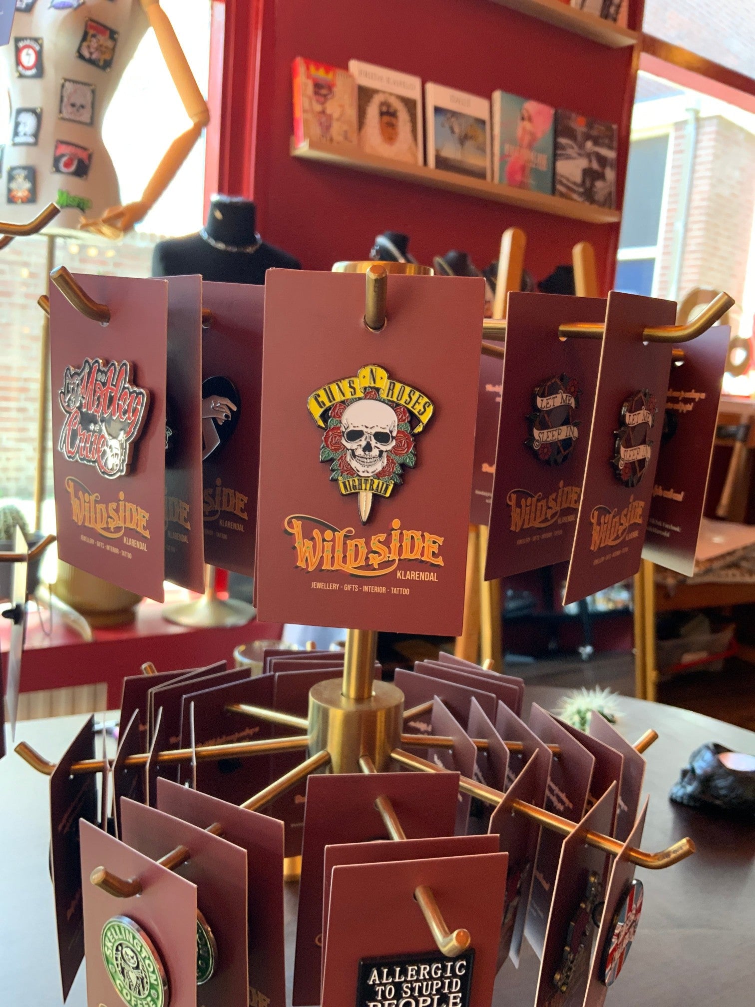 WILDSIDE Guns N Roses skull and roses enamel pin on a display stand. Features yellow text and red roses.
