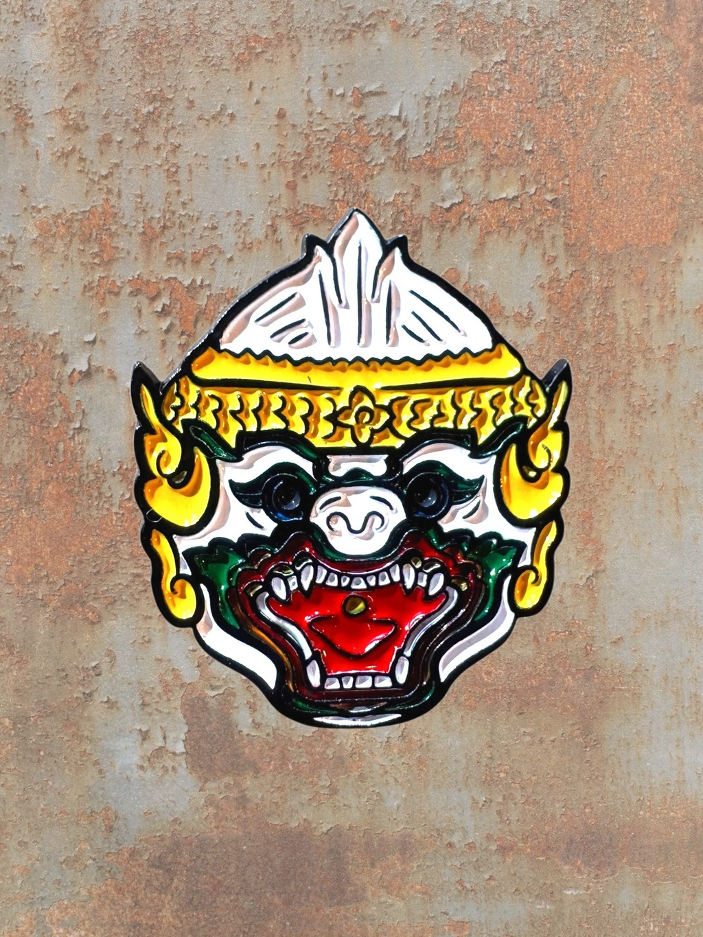 WILDSIDE mask pin featuring a fierce Hanuman face with white, gold, green, and red enamel details.