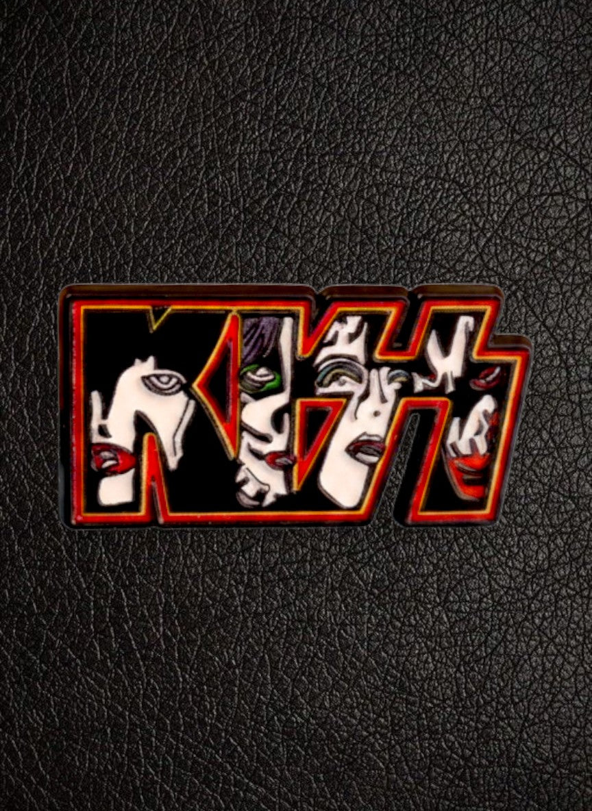 WILDSIDE Kiss logo pin featuring four faces in black, white, and red with a red and yellow border.