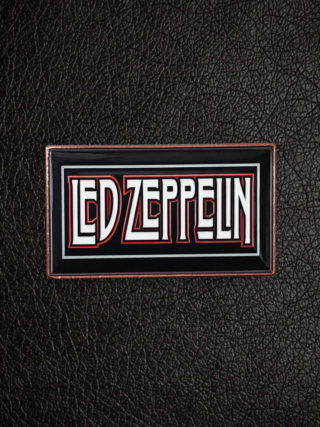WILDSIDE Led Zeppelin rectangular enamel pin with white and red lettering on a black background with a copper-colored border.