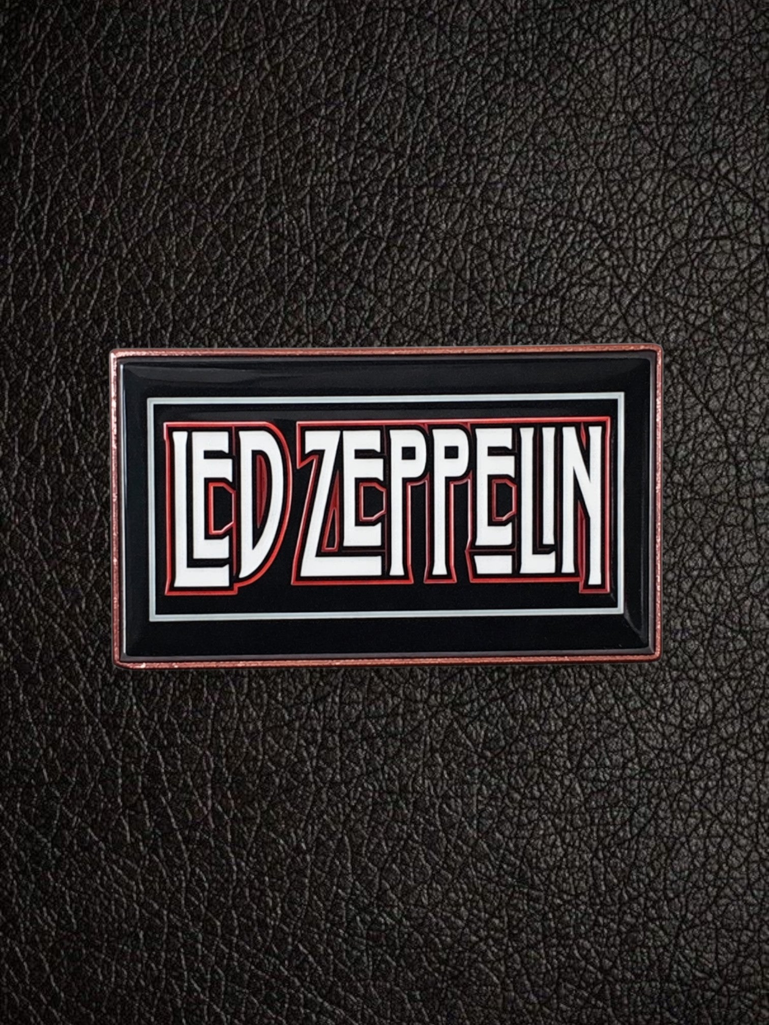 WILDSIDE Led Zeppelin rectangular enamel pin with white and red lettering on a black background with a copper-colored border.