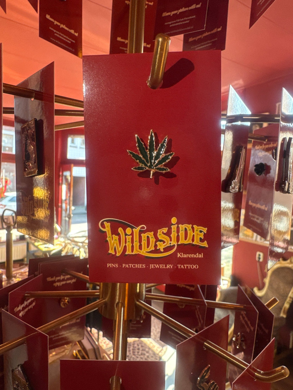 WILDSIDE green marijuana leaf enamel pin with gold trim. Perfect for jackets and bags.
