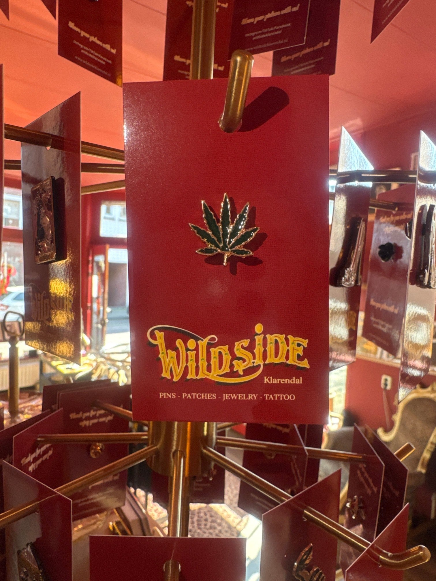 WILDSIDE green marijuana leaf enamel pin with gold trim. Perfect for jackets and bags.