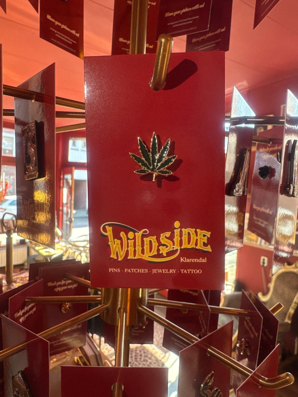 WILDSIDE green marijuana leaf enamel pin with gold trim. Perfect for jackets and bags.