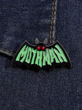 WILDSIDE Mothman bat-shaped enamel pin with green lettering and red glowing eyes.