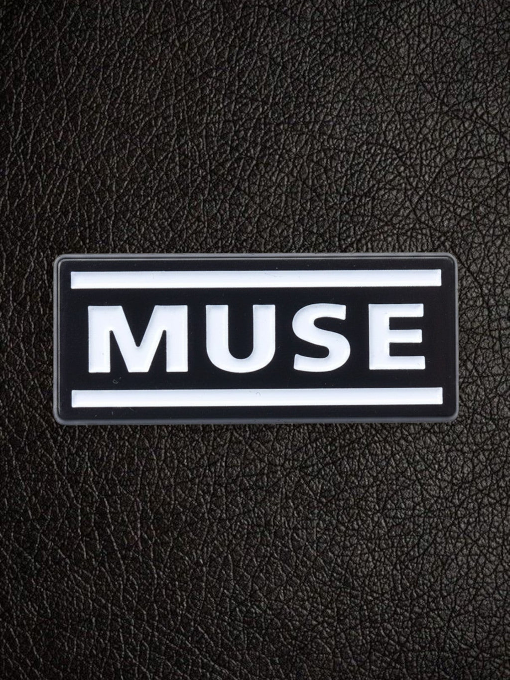 WILDSIDE black rectangular pin with white text spelling MUSE, featuring two white horizontal lines above and below the text.