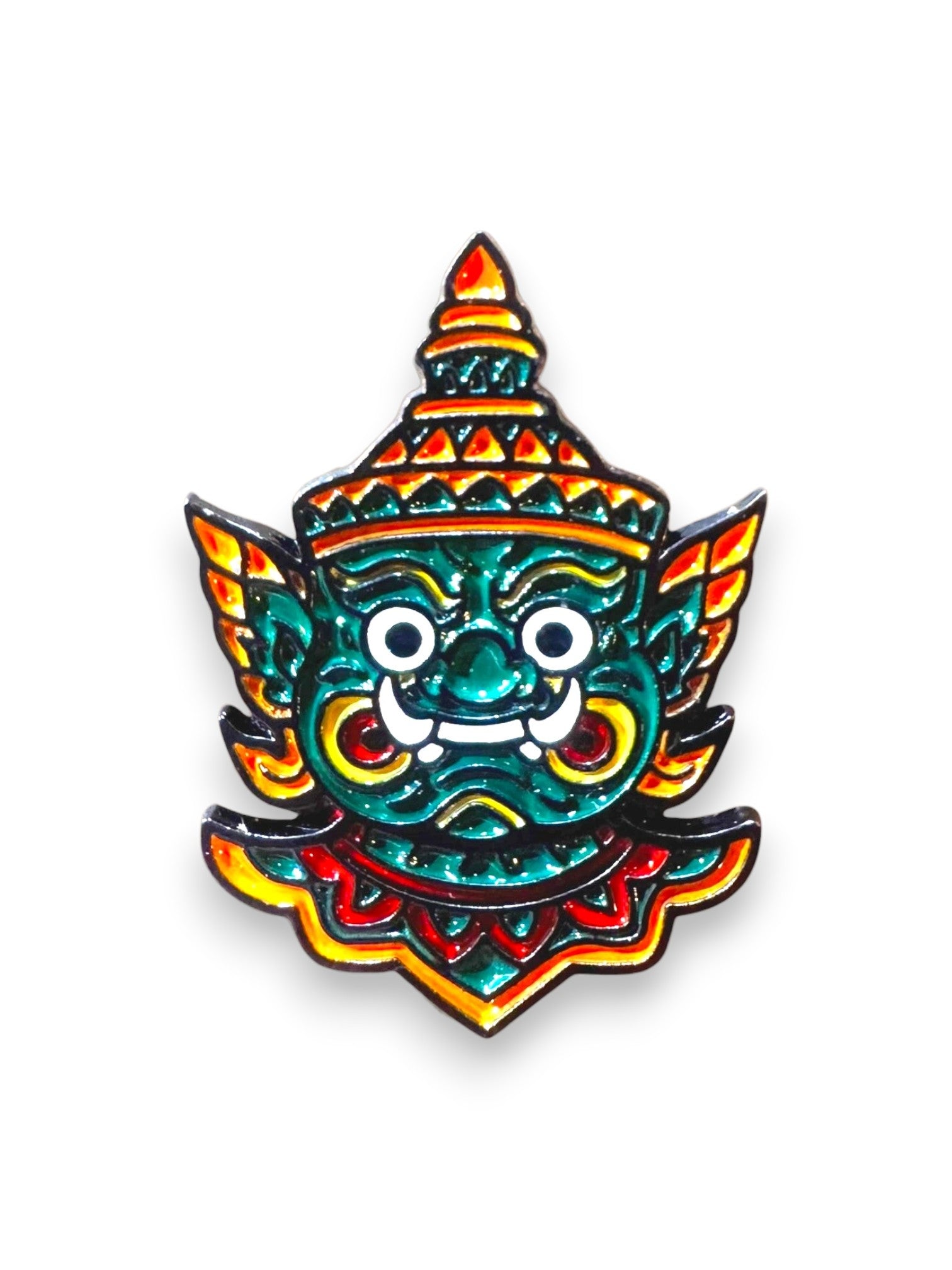 WILDSIDE enamel pin featuring a green mythical creature mask with a red and yellow headdress and ornate details.