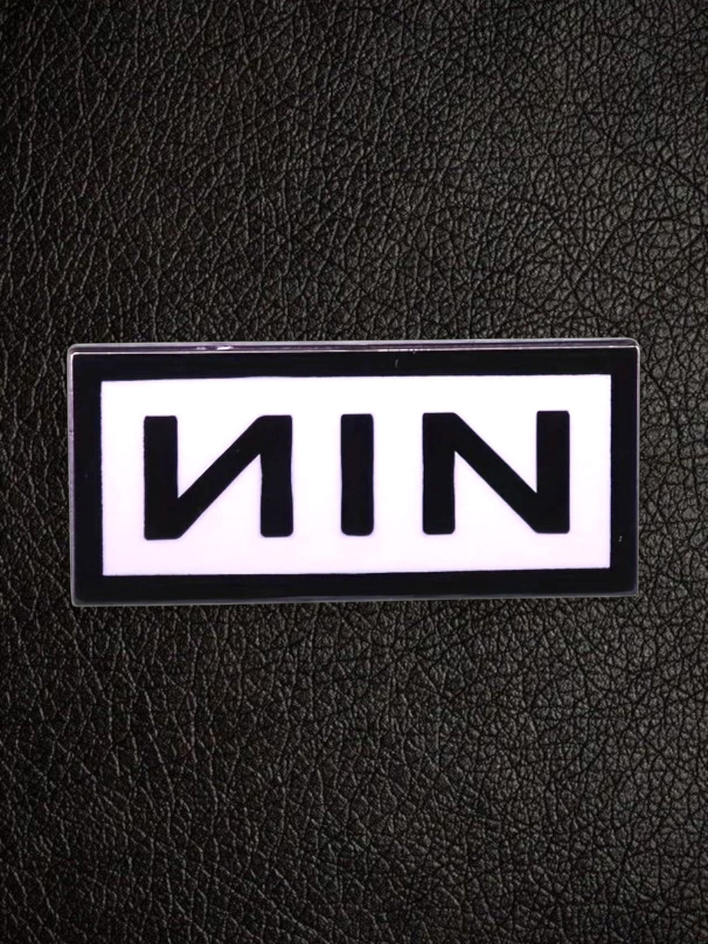WILDSIDE Nine Inch Nails NIN logo pin with black lettering on a white background, rectangular shape.
