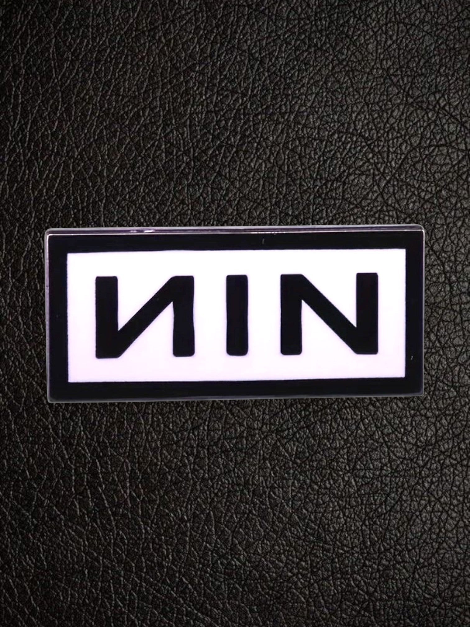 WILDSIDE Nine Inch Nails NIN logo pin with black lettering on a white background, rectangular shape.
