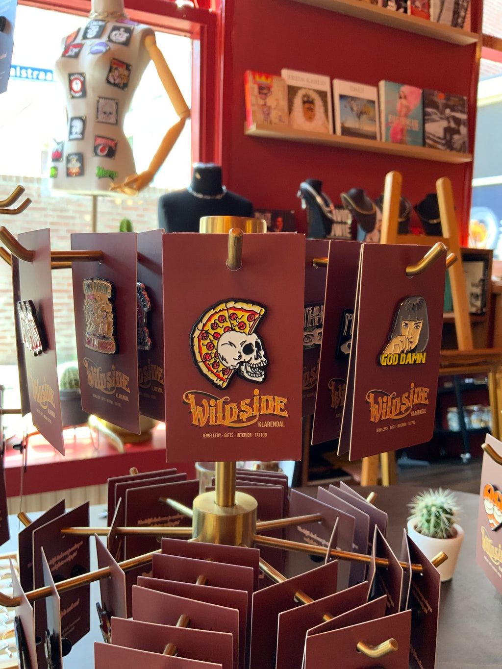 WILDSIDE pizza skull enamel pin with a slice of pizza on its head. Perfect for jackets and bags.