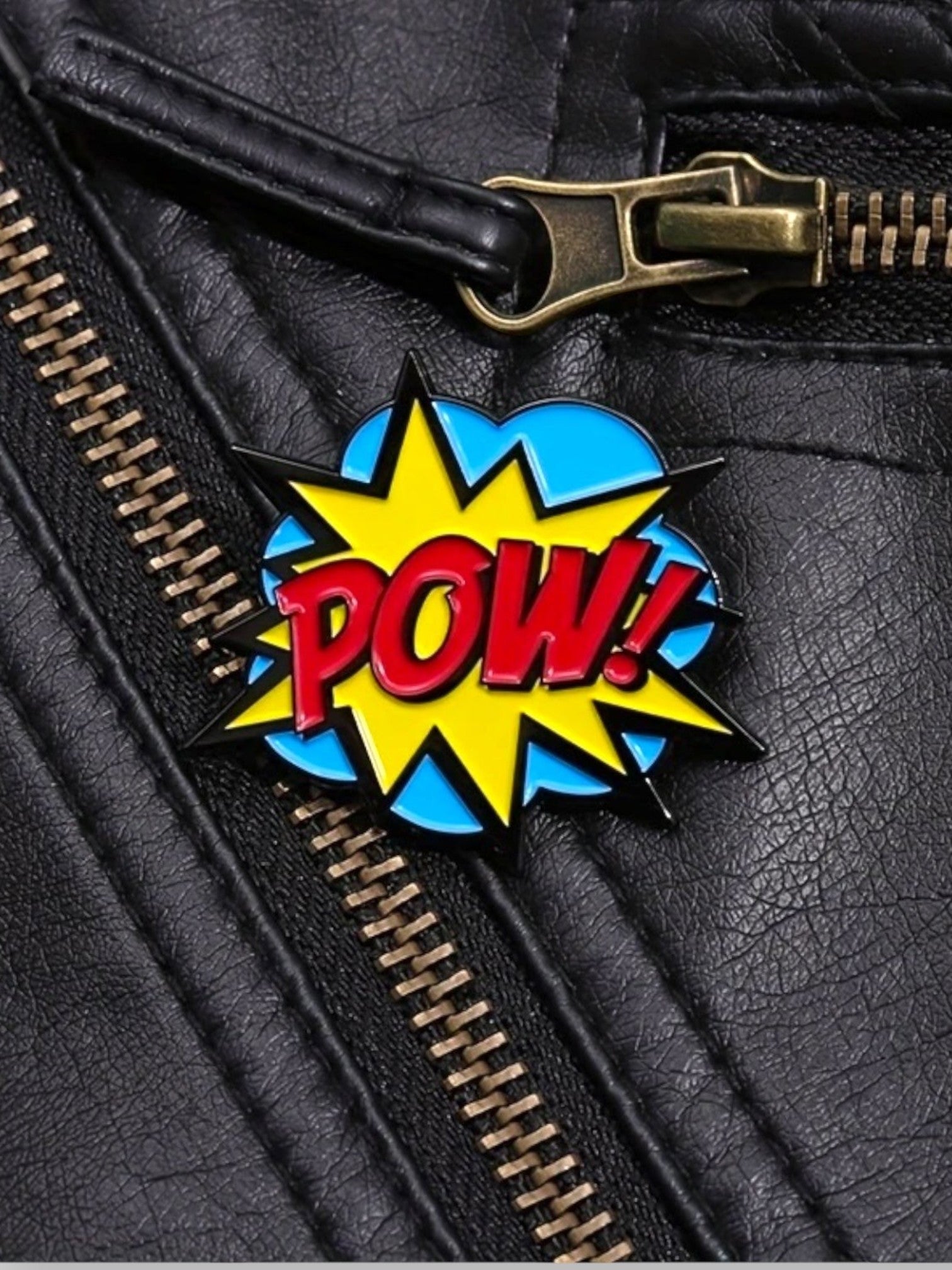 WILDSIDE PopArt POW enamel pin on black faux leather jacket with brass zipper detail.