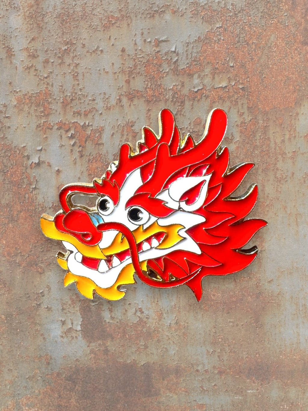 WILDSIDE red and yellow enamel dragon head pin with gold trim. Features intricate details and a fierce expression.