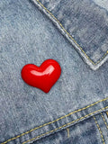 WILDSIDE red heart-shaped enamel pin on denim jacket.