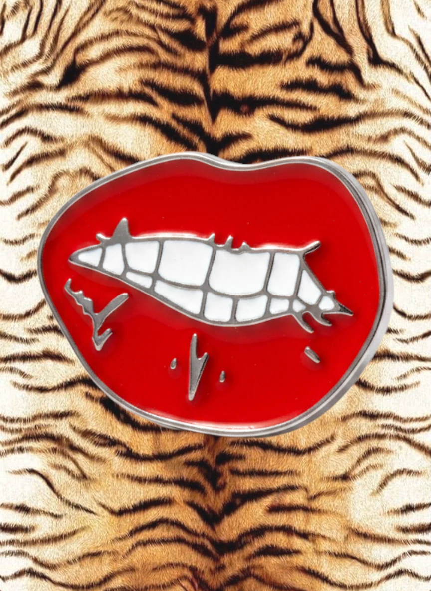 WILDSIDE red lips pin with silver teeth detail on a tiger print background.