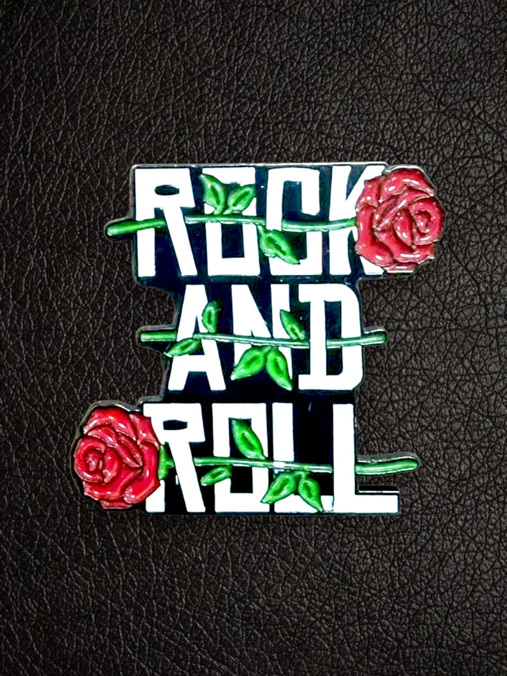 WILDSIDE rock and roll pin with red roses and green leaves, black background with white text.