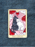 WILDSIDE Tarot The Lovers enamel pin featuring two cats, one black and one white, embracing with a heart and rays behind them.
