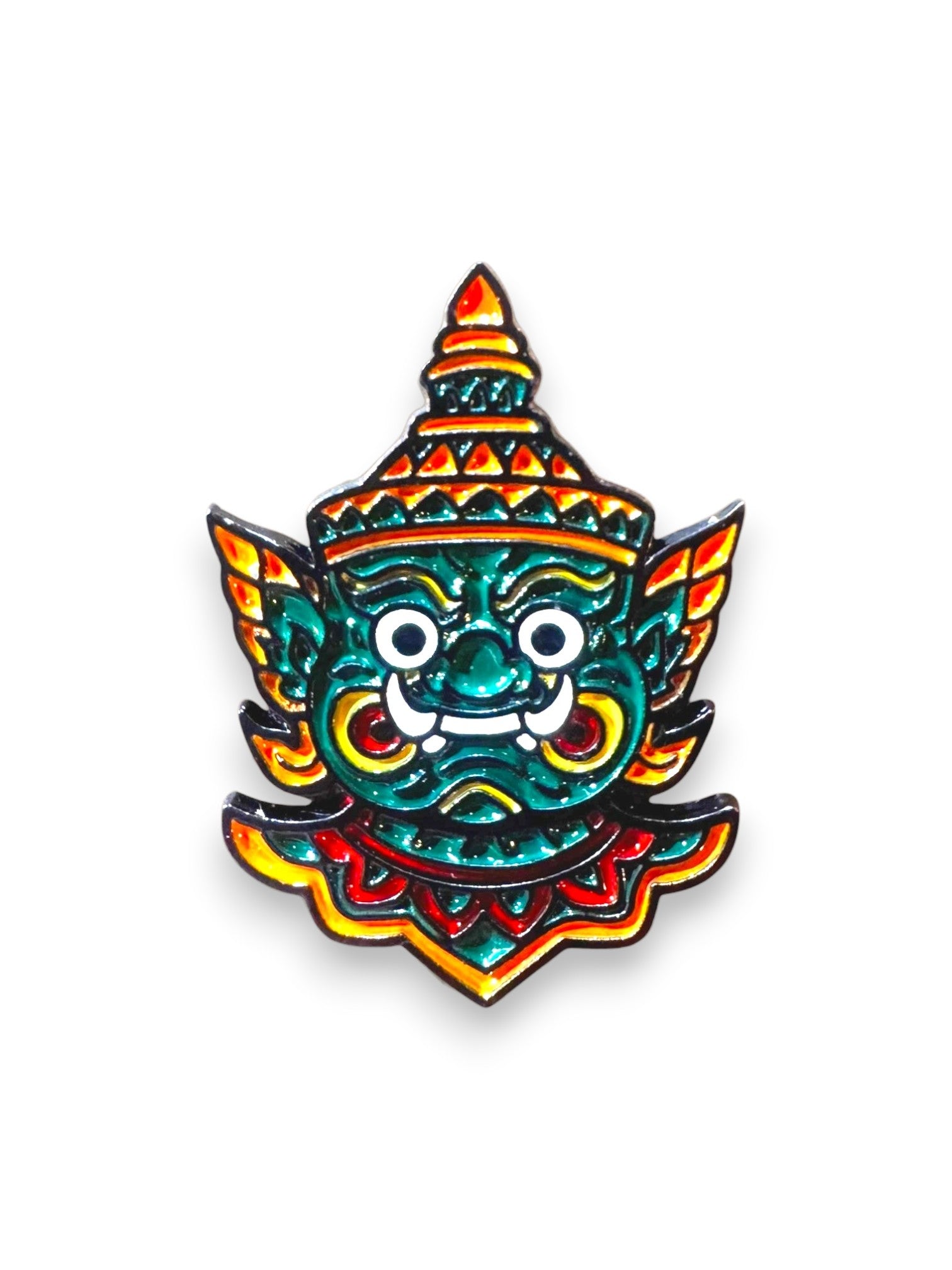 WILDSIDE green enamel pin of a traditional Thai demon mask with red and yellow accents.