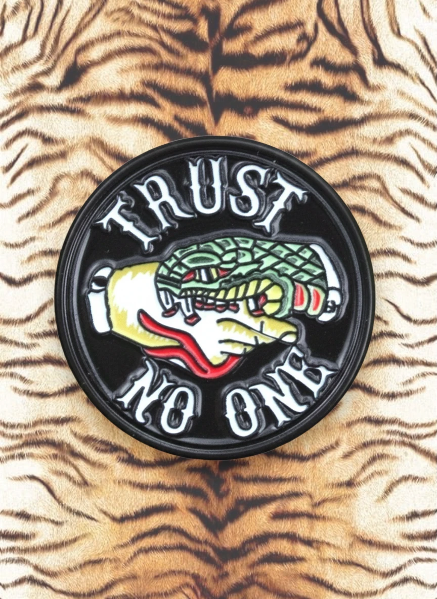 WILDSIDE Trust No One pin featuring a hand crushing a snake, with red and yellow accents.