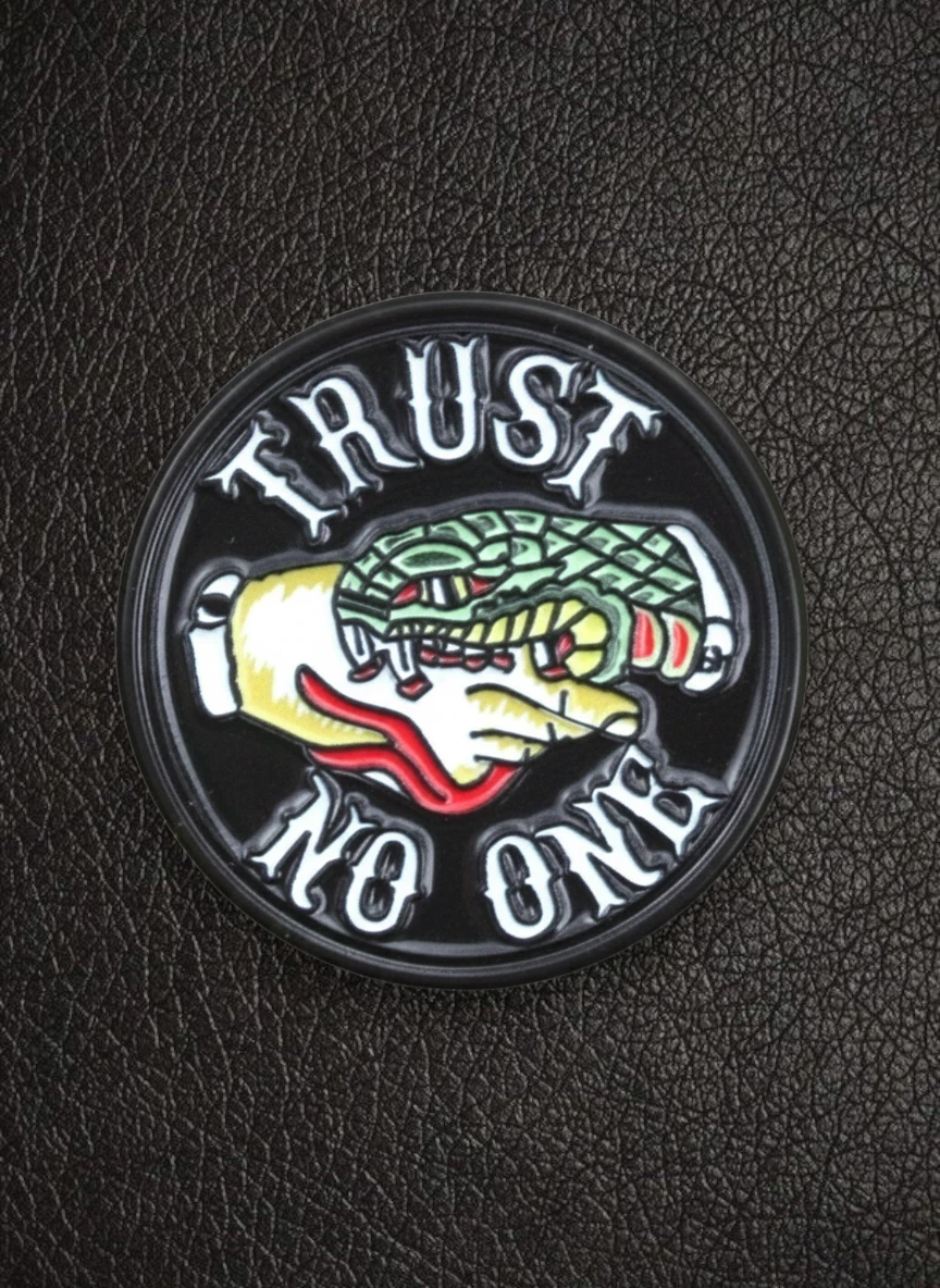 WILDSIDE Trust No One pin featuring a hand holding a snake, with text in a gothic font.