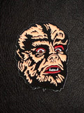WILDSIDE Werewolf Face Enamel Pin with black, red, and tan details. Horror accessory.